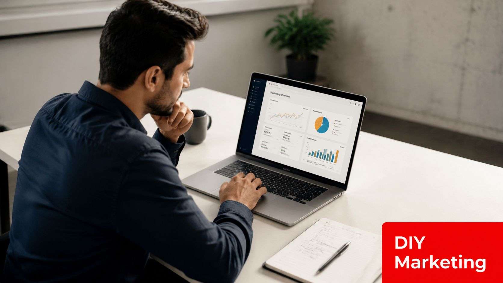 A professional man sitting at a desk and analyzing digital marketing data on his laptop screen.